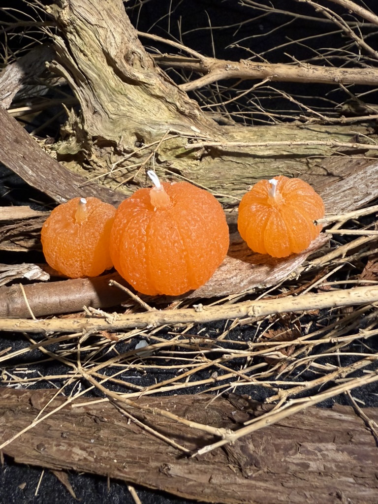 Drei orange Kürbiskerzen
